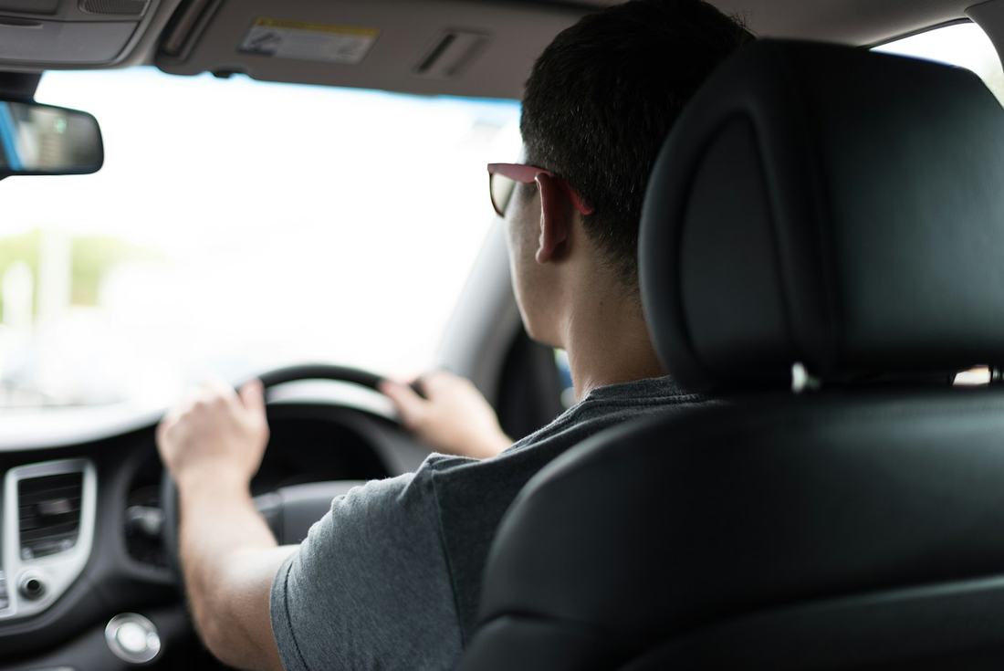 Aluno com as mãos no volante durante uma aula de direção